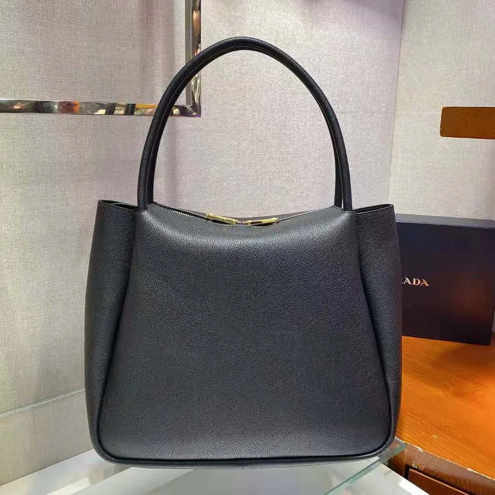 Prada Medium Leather handbag with the Prada Metal Lettering Logo Illuminating Its Center for Women in Black Prada Medium Leather handbag with the Prada Metal Lettering Logo Illuminating Its Center for Women in Black