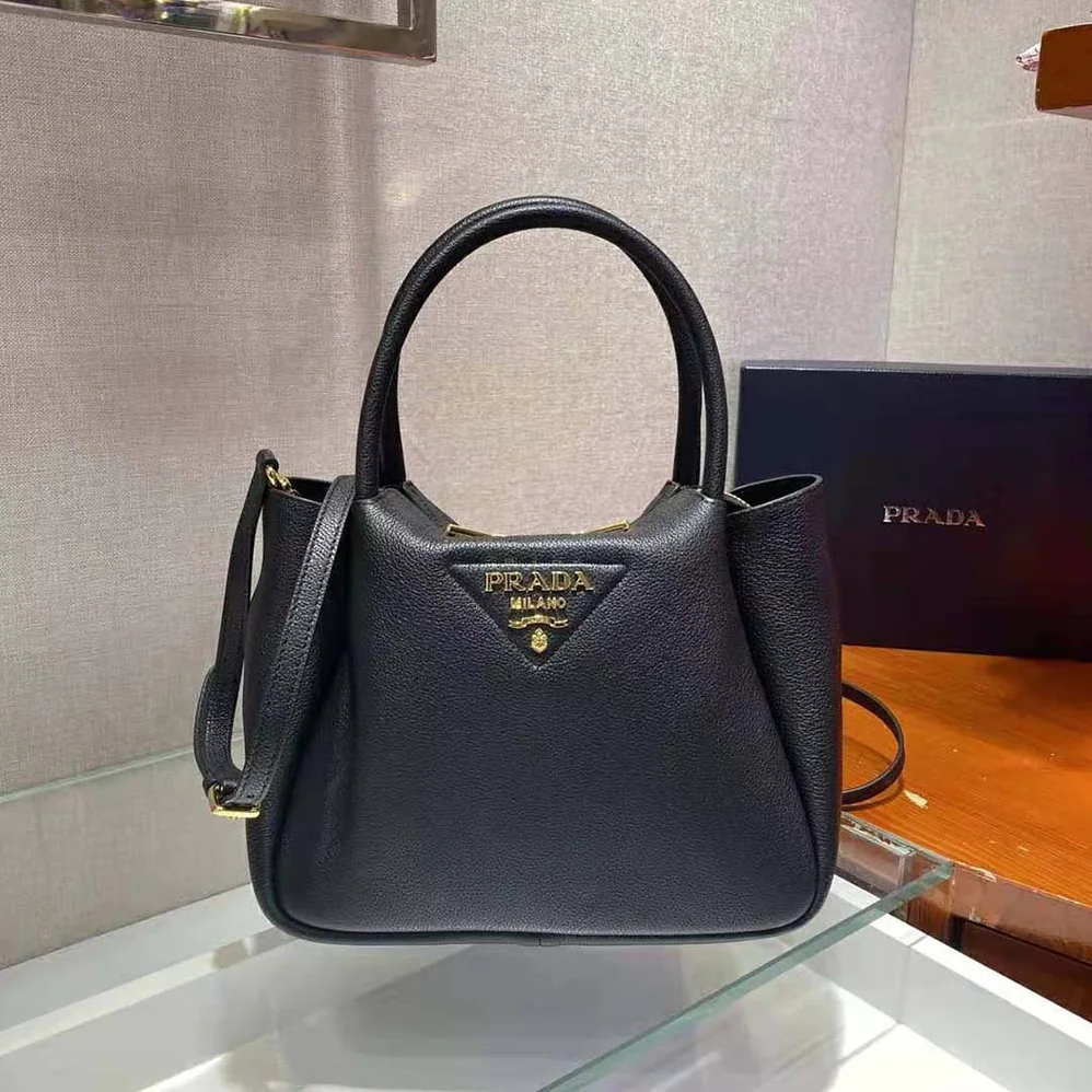 Prada Small leather Handbag with the Prada Metal Lettering Logo Illuminating Its Center for Women Prada Small leather Handbag with the Prada Metal Lettering Logo Illuminating Its Center for Women