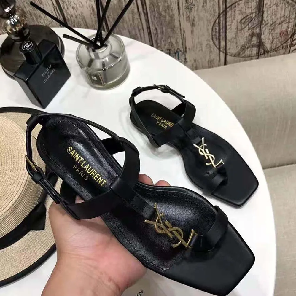 Saint Laurent YSL Cassandra Flat Sandals in Smooth Leather with Gold-tone Monogram for Women in Black