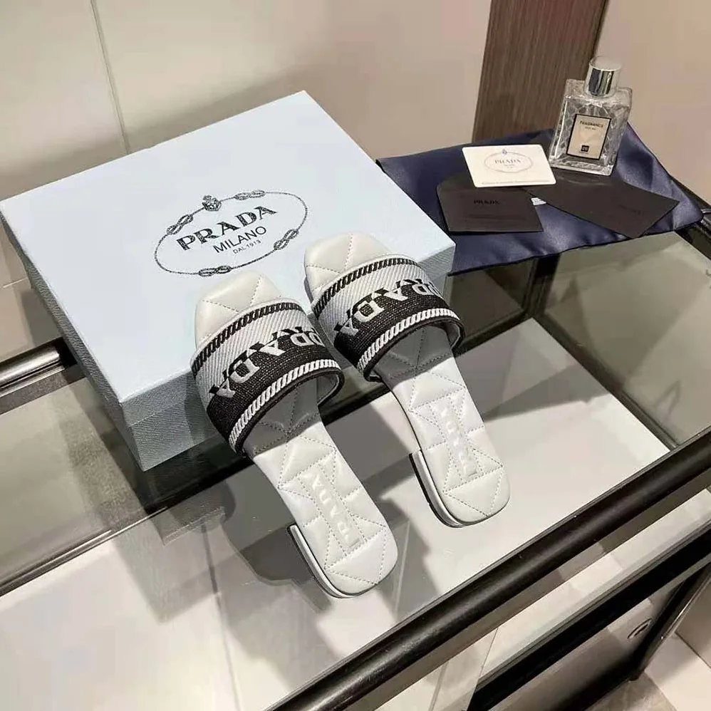 Prada Embroidered Fabric Slides With Embroidered Lettering Logo for Women in White Prada Embroidered Fabric Slides With Embroidered Lettering Logo for Women in White