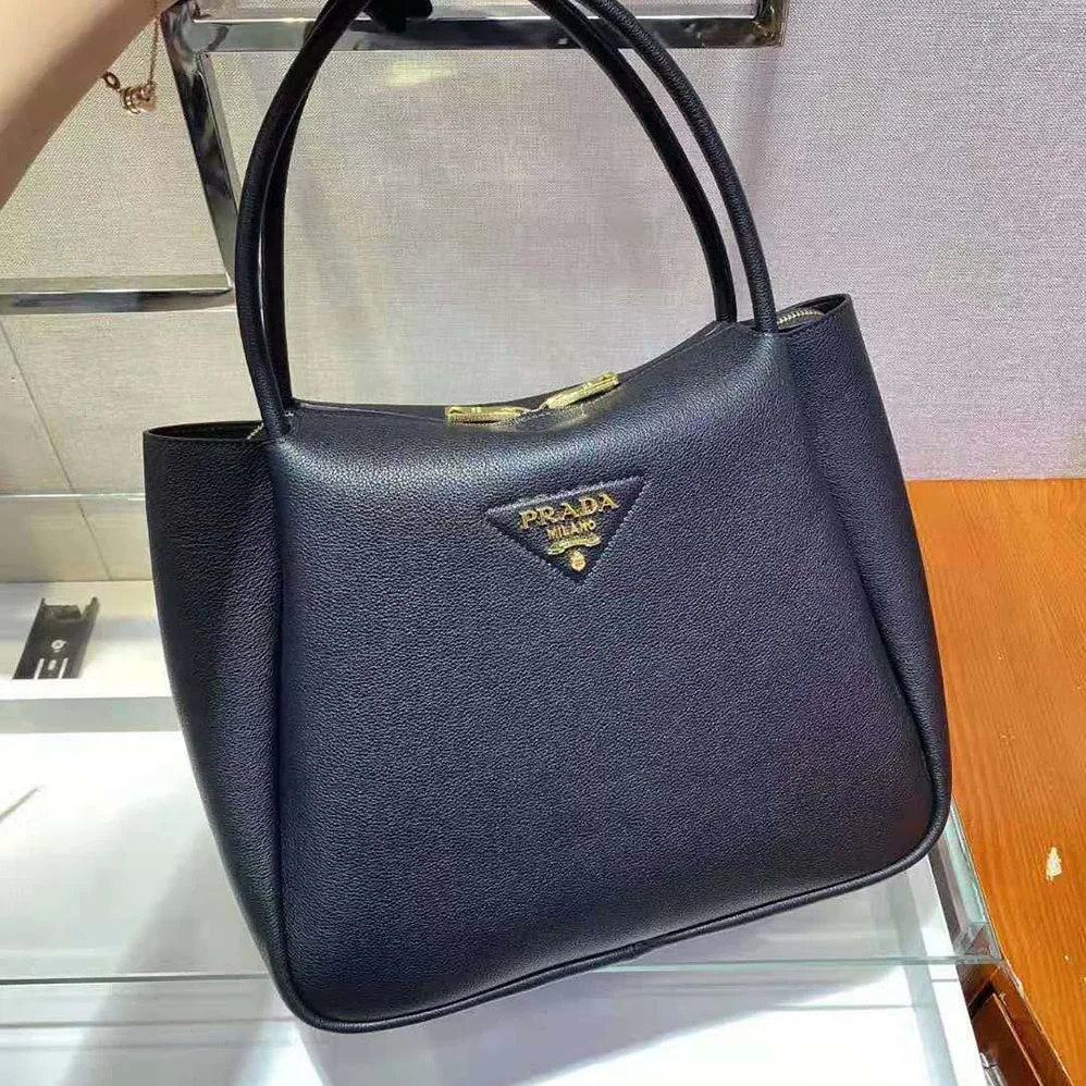 Prada Medium Leather handbag with the Prada Metal Lettering Logo Illuminating Its Center for Women in Black Prada Medium Leather handbag with the Prada Metal Lettering Logo Illuminating Its Center for Women in Black