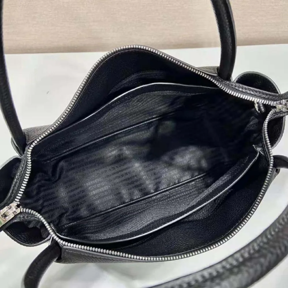 Prada Large Leather Handbag with the Prada Metal Lettering Logo Gleaming at Its Center for Women in Black Prada Large Leather Handbag with the Prada Metal Lettering Logo Gleaming at Its Center for Women in Black