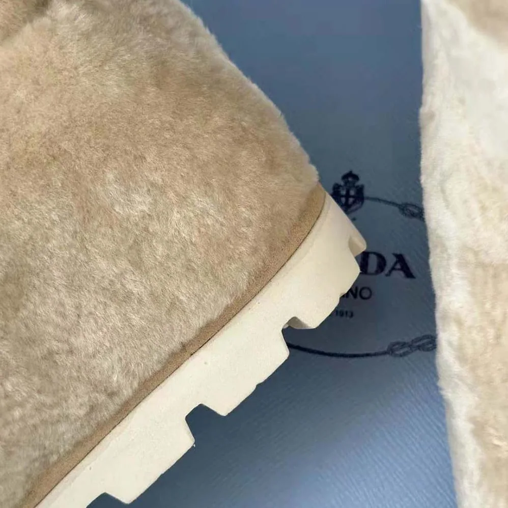 Prada Shearling Booties with Enameled Metal Triangle Logo for Women in Beige