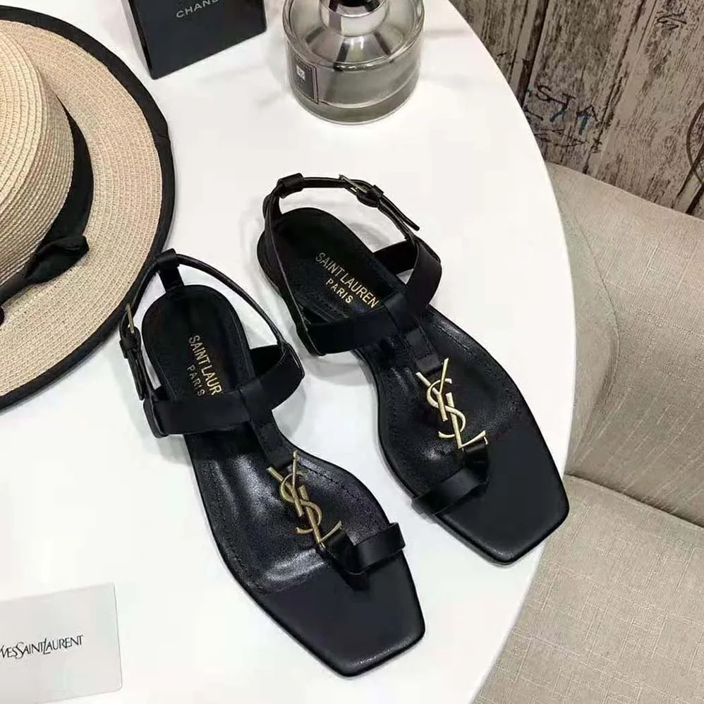 Saint Laurent YSL Cassandra Flat Sandals in Smooth Leather with Gold-tone Monogram for Women in Black