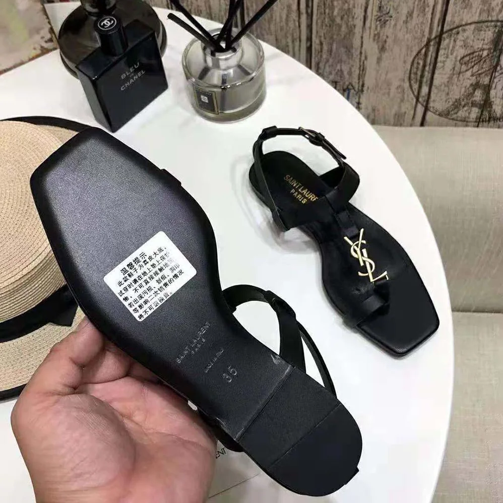 Saint Laurent YSL Cassandra Flat Sandals in Smooth Leather with Gold-tone Monogram for Women in Black