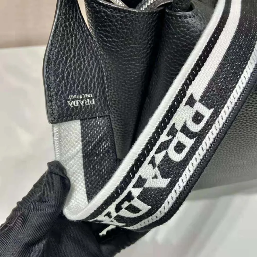 Prada Large Leather Handbag with the Prada Metal Lettering Logo Gleaming at Its Center for Women in Black Prada Large Leather Handbag with the Prada Metal Lettering Logo Gleaming at Its Center for Women in Black