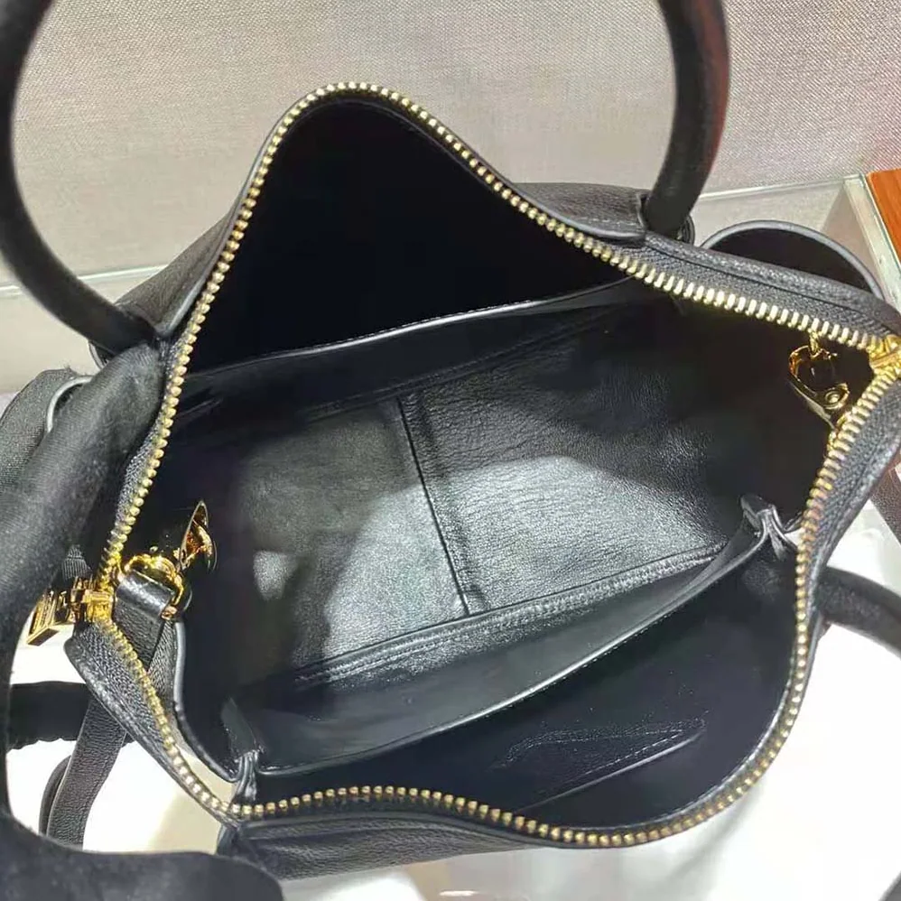 Prada Small leather Handbag with the Prada Metal Lettering Logo Illuminating Its Center for Women Prada Small leather Handbag with the Prada Metal Lettering Logo Illuminating Its Center for Women