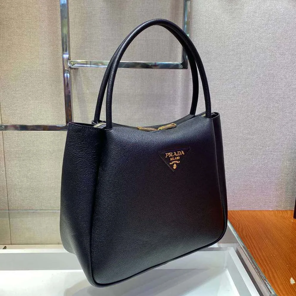 Prada Medium Leather handbag with the Prada Metal Lettering Logo Illuminating Its Center for Women in Black Prada Medium Leather handbag with the Prada Metal Lettering Logo Illuminating Its Center for Women in Black