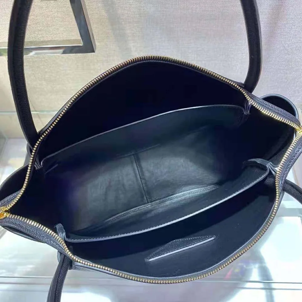 Prada Medium Leather handbag with the Prada Metal Lettering Logo Illuminating Its Center for Women in Black Prada Medium Leather handbag with the Prada Metal Lettering Logo Illuminating Its Center for Women in Black