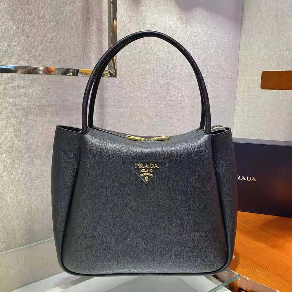 Prada Medium Leather handbag with the Prada Metal Lettering Logo Illuminating Its Center for Women in Black Prada Medium Leather handbag with the Prada Metal Lettering Logo Illuminating Its Center for Women in Black