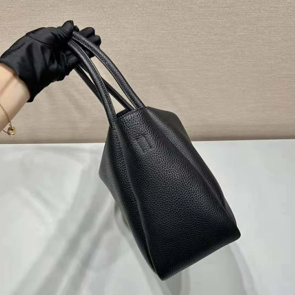 Prada Large Leather Handbag with the Prada Metal Lettering Logo Gleaming at Its Center for Women in Black Prada Large Leather Handbag with the Prada Metal Lettering Logo Gleaming at Its Center for Women in Black