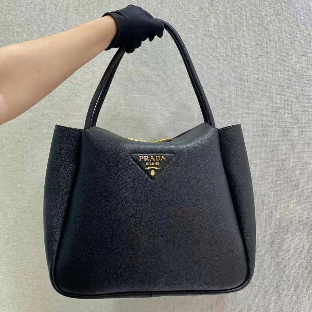 Prada Medium Leather handbag with the Prada Metal Lettering Logo Illuminating Its Center for Women in Black Prada Medium Leather handbag with the Prada Metal Lettering Logo Illuminating Its Center for Women in Black