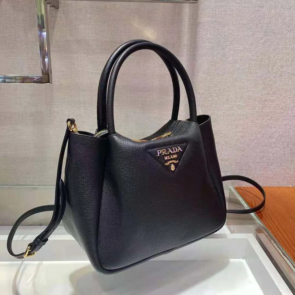 Prada Small leather Handbag with the Prada Metal Lettering Logo Illuminating Its Center for Women Prada Small leather Handbag with the Prada Metal Lettering Logo Illuminating Its Center for Women
