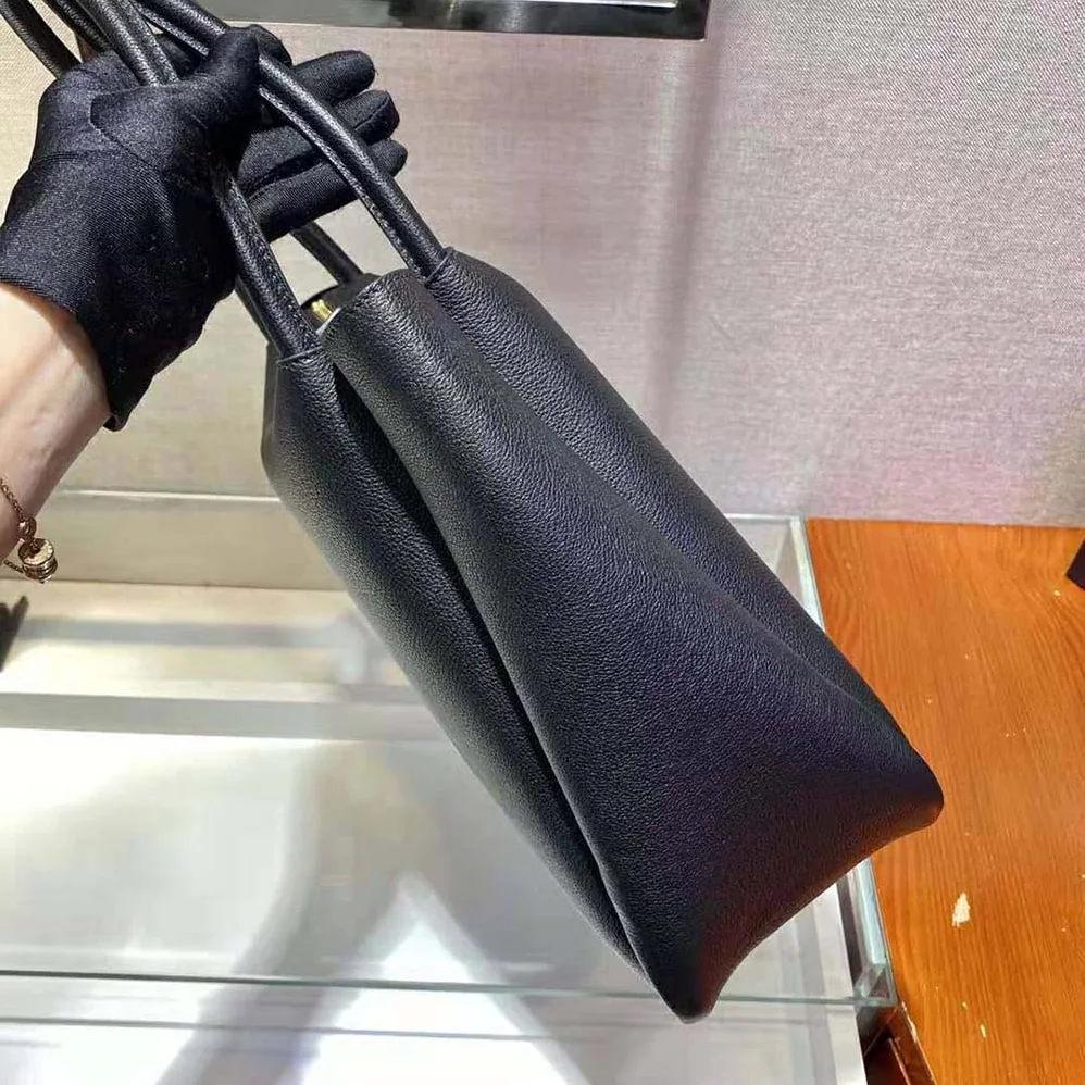 Prada Medium Leather handbag with the Prada Metal Lettering Logo Illuminating Its Center for Women in Black Prada Medium Leather handbag with the Prada Metal Lettering Logo Illuminating Its Center for Women in Black